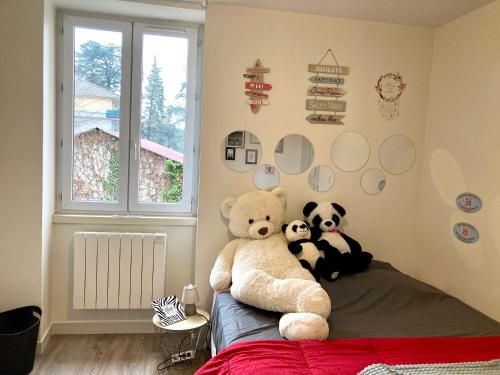 three stuffed animals sitting on a bed in a bedroom at Le Cosy, accès terrasse de l'établissement in Rives