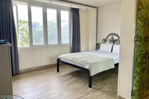 - une chambre avec un lit dans une pièce dotée de fenêtres dans l'établissement Bao Ngoc Hotel, à Hô-Chi-Minh-Ville