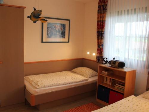 um pequeno quarto com uma cama e uma janela em Ferienhaus Nr 59, Kategorie Komfort, Feriendorf Hochbergle, Allgäu em Karlsebene