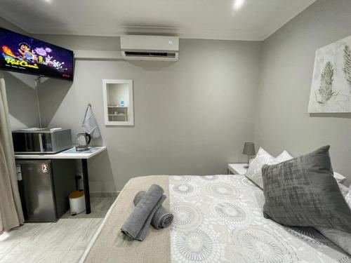 1 dormitorio con 1 cama y TV en la pared en Guest house on Gillian Unit 4, en Ballito