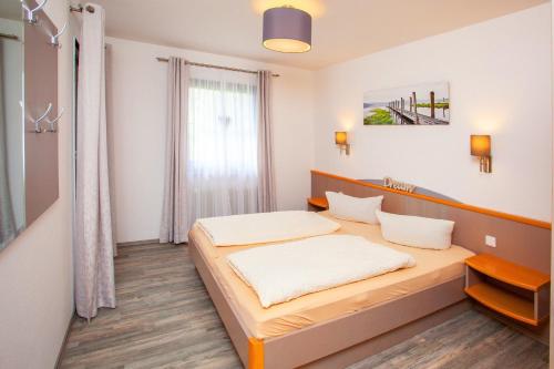 een slaapkamer met een bed in een kamer bij Ferienhaus Nr 49, Kategorie Premium, Feriendorf Hochbergle, Allgäu in Karlsebene