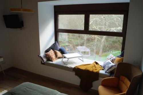 Habitación con ventana, sofá y mesa. en Molino Mellado en Casavieja