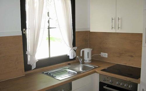 uma cozinha com um lavatório e uma janela em Ferienhaus Nr 18, Kategorie Komfort, Feriendorf Hochbergle, Allgäu em Bichel