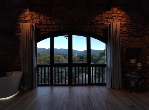 an open door to a balcony with a mountain view at Alojamiento MAS EL CASTELL DEL BRULL in El Brull