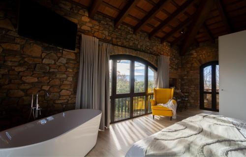 a bathroom with a large tub and a yellow chair at Alojamiento MAS EL CASTELL DEL BRULL 