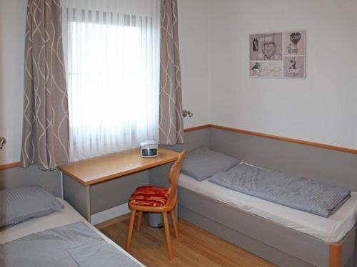 a small room with a bed and a desk and a window at Ferienhaus Nr 50, Kategorie Premium, Feriendorf Hochbergle, Allgäu in Karlsebene