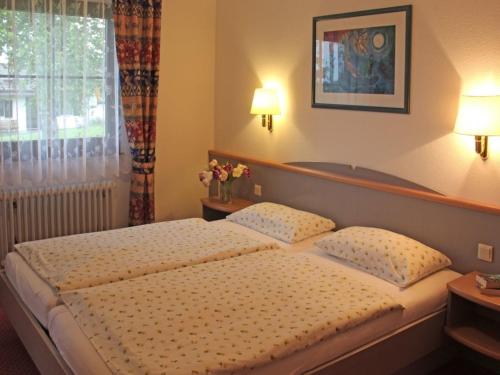 1 dormitorio con 1 cama con 2 almohadas y ventana en Ferienhaus Nr 67, Kategorie Komfort, Feriendorf Hochbergle, Allgäu, en Karlsebene