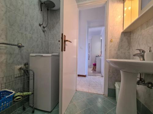 a bathroom with a sink and a small refrigerator at Apartments Slavko 1179 in Banjole