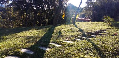 a shadow of a tree on a grass field at RECANTO DO LEÃO in Aiuruoca