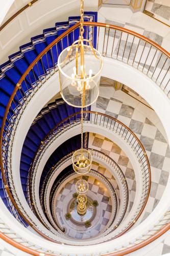 an overhead view of a spiral staircase with a chandelier at Excelsior Hotel Ernst am Dom in Cologne