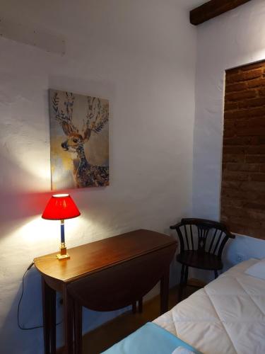 a bedroom with a desk with a lamp and a bed at Casa do Páteo in Vila Nova da Baronia