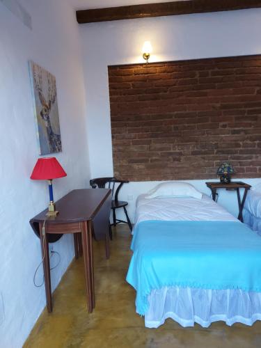 a bedroom with a bed and a table with a lamp at Casa do Páteo in Vila Nova da Baronia