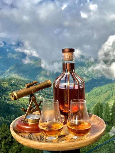 a bottle of whiskey and two glasses on a table at Radisson Kufri in Shimla