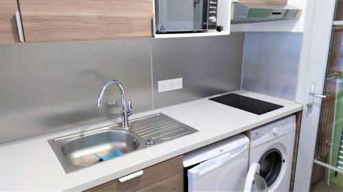 une cuisine avec un évier et une machine à laver dans l'établissement Delille centre ville 01, à Nice