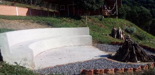 a concrete bench sitting on top of a hill at Recanto do Leão in Alagoa