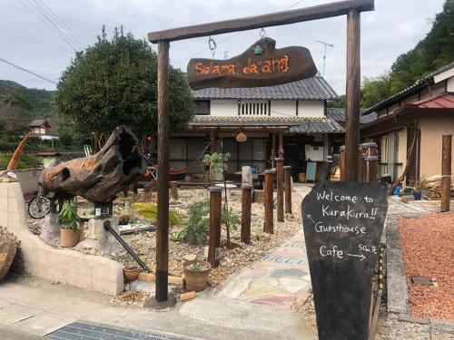 a sign in front of a restaurant with a cow statue at 吉野 古民家一棟貸しの体験型ゲストハウスKuraKura in Kami-ichi