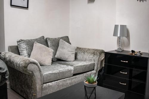 a living room with a couch with pillows on it at BvApartments Queensgate 1 in Huddersfield