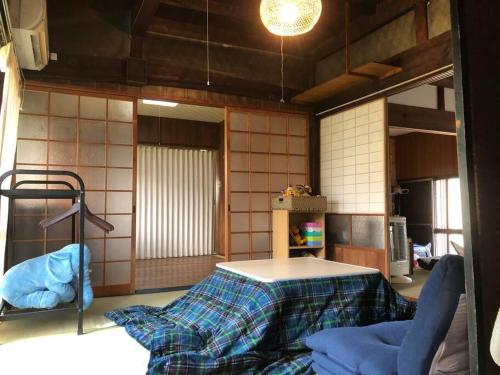 a kitchen with a table in the middle of a room at 吉野 古民家一棟貸しの体験型ゲストハウスKuraKura in Kami-ichi