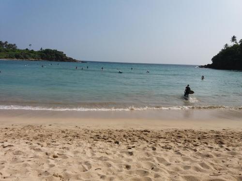 a person standing in the water at the beach at Cashew Villa Hiriketiya in Hiriketiya