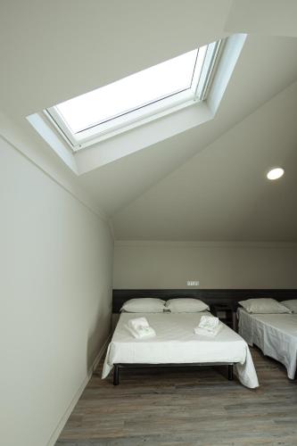two beds in a room with a skylight at Rua Grande Hotel in Viana do Castelo