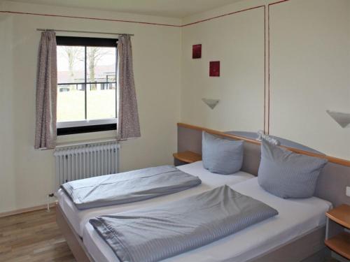 - une chambre avec un lit et une fenêtre dans l'établissement Ferienhaus Nr 62, Kategorie Premium, Feriendorf Hochbergle, Allgäu, à Bichel