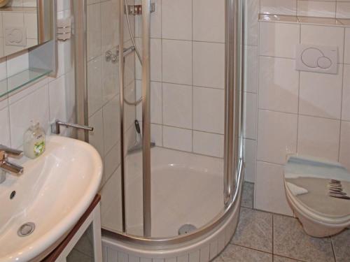 La salle de bains est pourvue d'une douche, d'un lavabo et de toilettes. dans l'établissement Ferienhaus Nr 62, Kategorie Premium, Feriendorf Hochbergle, Allgäu, à Bichel