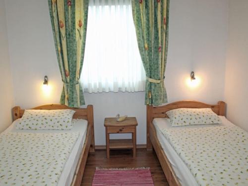 two beds in a small room with a window at Ferienhaus Nr 73, Kategorie Komfort L, Feriendorf Hochbergle, Allgäu in Bichel