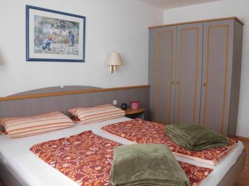 ein Bett mit zwei Kissen darauf in einem Schlafzimmer in der Unterkunft Ferienhaus Nr 137, Typ C, Feriendorf Hochbergle, Allgäu in Karlsebene