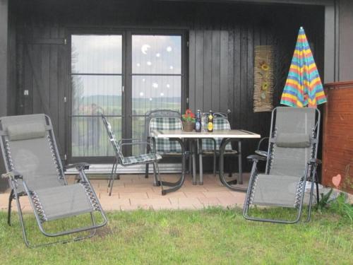 eine Terrasse mit Stühlen, einem Tisch und Stühlen in der Unterkunft Ferienhaus Nr 137, Typ C, Feriendorf Hochbergle, Allgäu in Karlsebene
