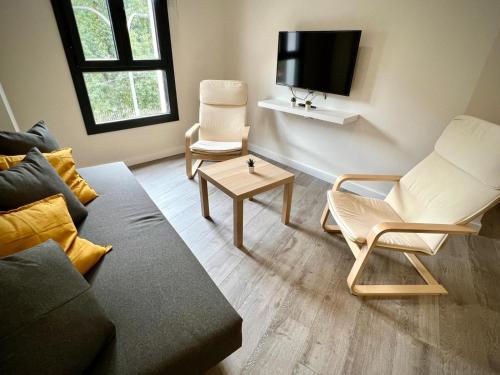 een woonkamer met een bank en stoelen en een tv bij Apartamento Dama de noche in Córdoba