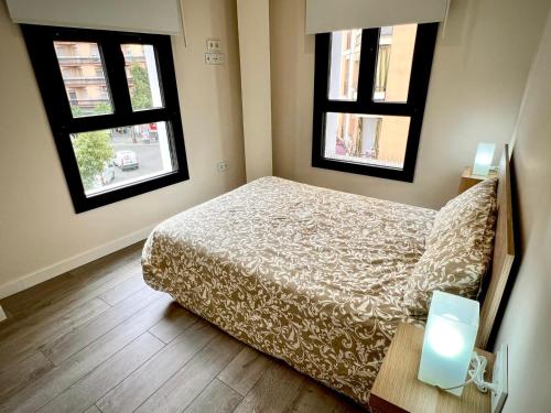 een slaapkamer met een bed en 2 ramen bij Apartamento Dama de noche in Córdoba