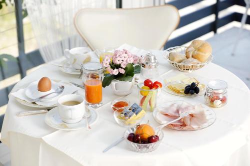 a white table with breakfast foods and coffee on it at Hotel Garni Ogris Am See in Velden am Wörthersee