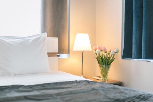 a bedroom with a bed and a vase of flowers at AirPark Balice in Balice