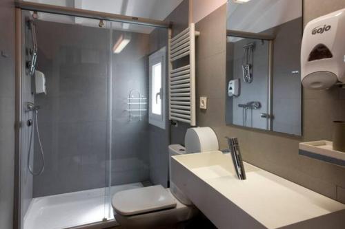 a bathroom with a shower and a sink and a toilet at Pensión Iturriza in Donostia-San Sebastián