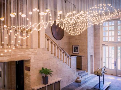 a room with a staircase and a chandelier at SO/ Berlin Das Stue in Berlin