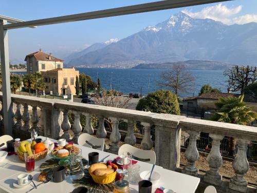 a table with food on a balcony with a view of the ocean at Residence Il Bosso in Domaso
