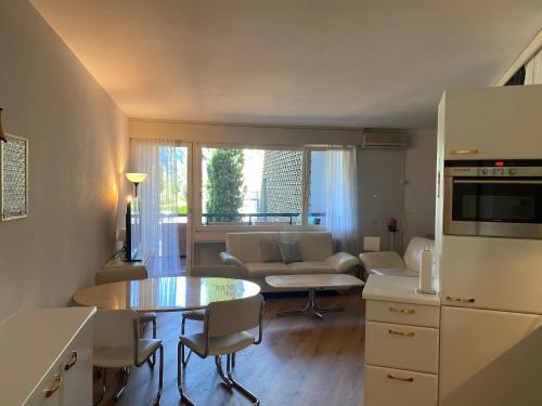 a kitchen and living room with a table and a couch at Holiday on the Lake Lugano 2-16 in Bissone