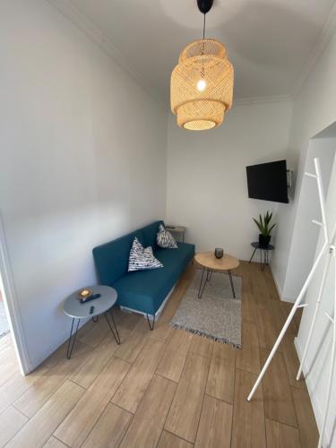 un salon avec un canapé bleu et une télévision dans l'établissement Appartement Rez de chaussé, à Amiens