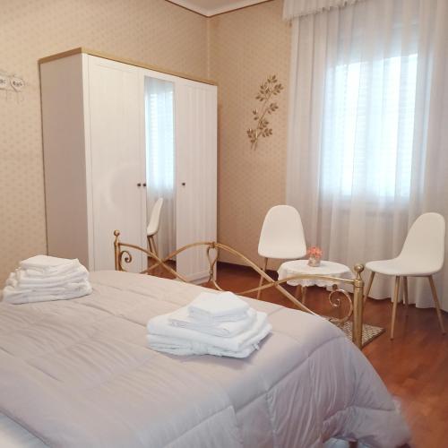 a bedroom with a bed with two chairs and a mirror at La Casa di Tino in Fontanellato
