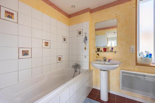 a bathroom with a tub and a sink and a bath tub at Maison L'Hippocampe in Saint-Aubin-sur-Mer
