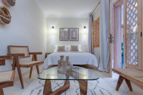 a bedroom with a bed and a glass table at Riad Le Saadien ,Adult only in Marrakech
