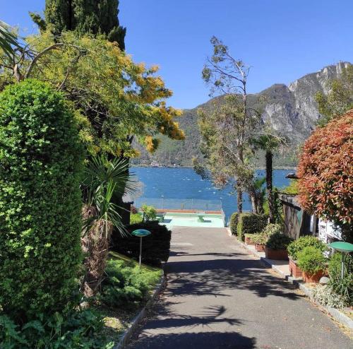 a walkway with a view of a lake and mountains at Holiday on the Lake Lugano 2-16 in Bissone