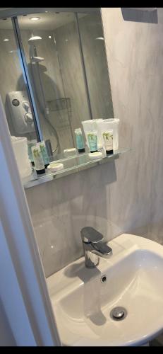 ein Badezimmer mit einem weißen Waschbecken und einem Spiegel in der Unterkunft Anchor Inn in Kempsey