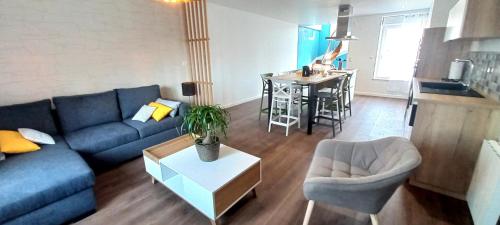 un salon avec un canapé bleu et une table dans l'établissement La Clé du Génie, à Ducey