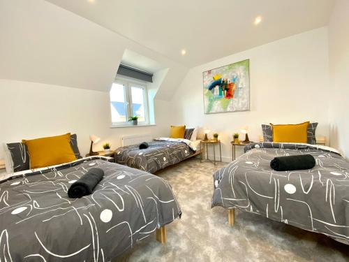 a bedroom with two beds and a couch at Stunning NEW Large 3 bedroom House - 5 Minutes to the nearest Beach! - Great Location - Garden - Parking - Fast WiFi - Smart TV - Newly decorated - sleeps up to 7! Close to Poole & Bournemouth & Sandbanks in Lytchett Minster