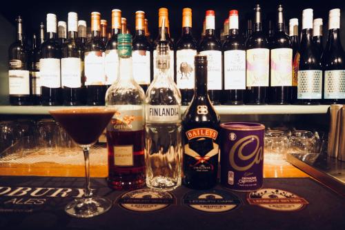 a bunch of bottles of alcohol sitting on a bar at Seven Stars in Ledbury