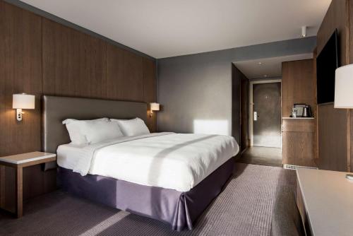 a hotel room with a large bed and a desk at Radisson Blu Manchester Airport in Hale
