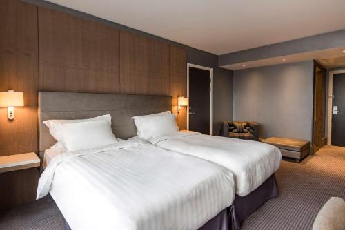 a large white bed in a hotel room at Radisson Blu Manchester Airport in Hale