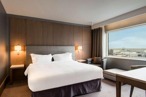 a hotel room with a large bed and a window at Radisson Blu Manchester Airport in Hale
