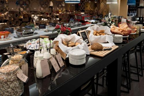 a buffet line with bread and other foods on plates at Radisson Blu Manchester Airport in Hale